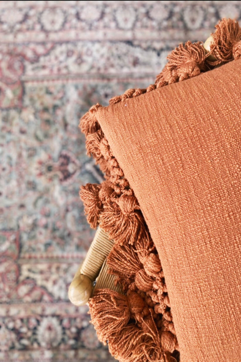 cushion with tassels, rust